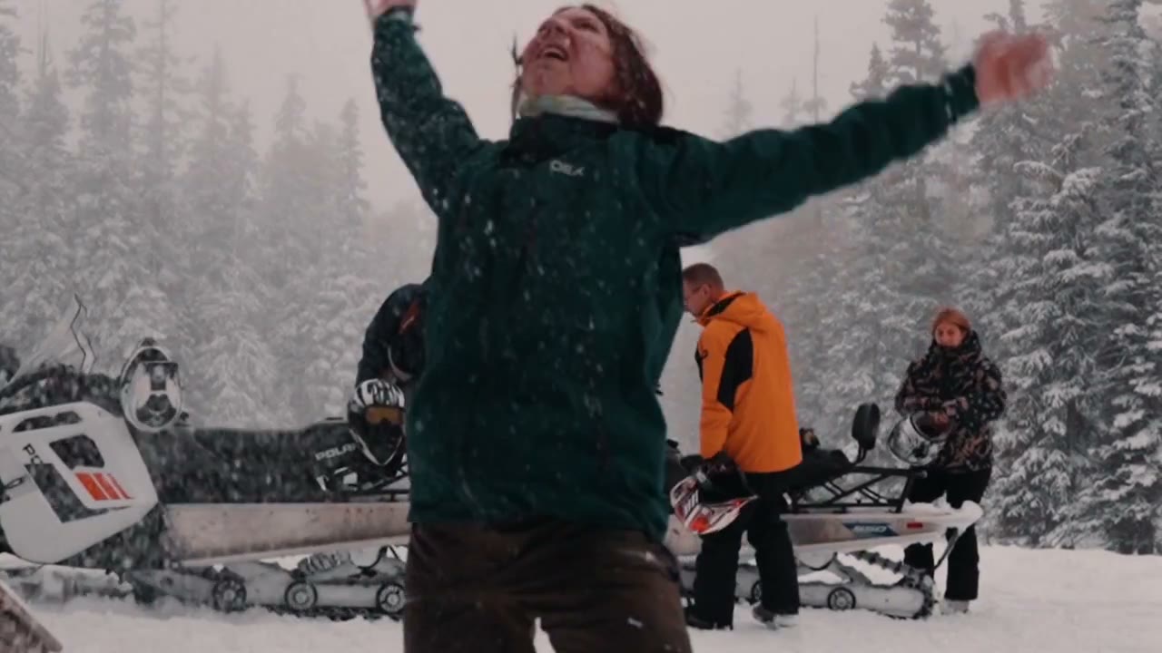 Laughing in falling snow beside parked sleds, a CCX best clip