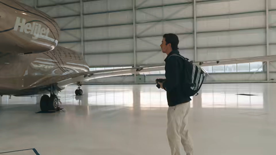 Private jet in a hangar, photographer walking the fuselage
