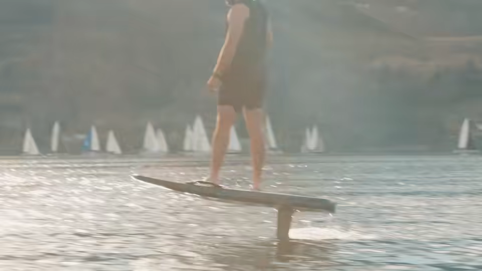 Efoil board cutting low over flat water
