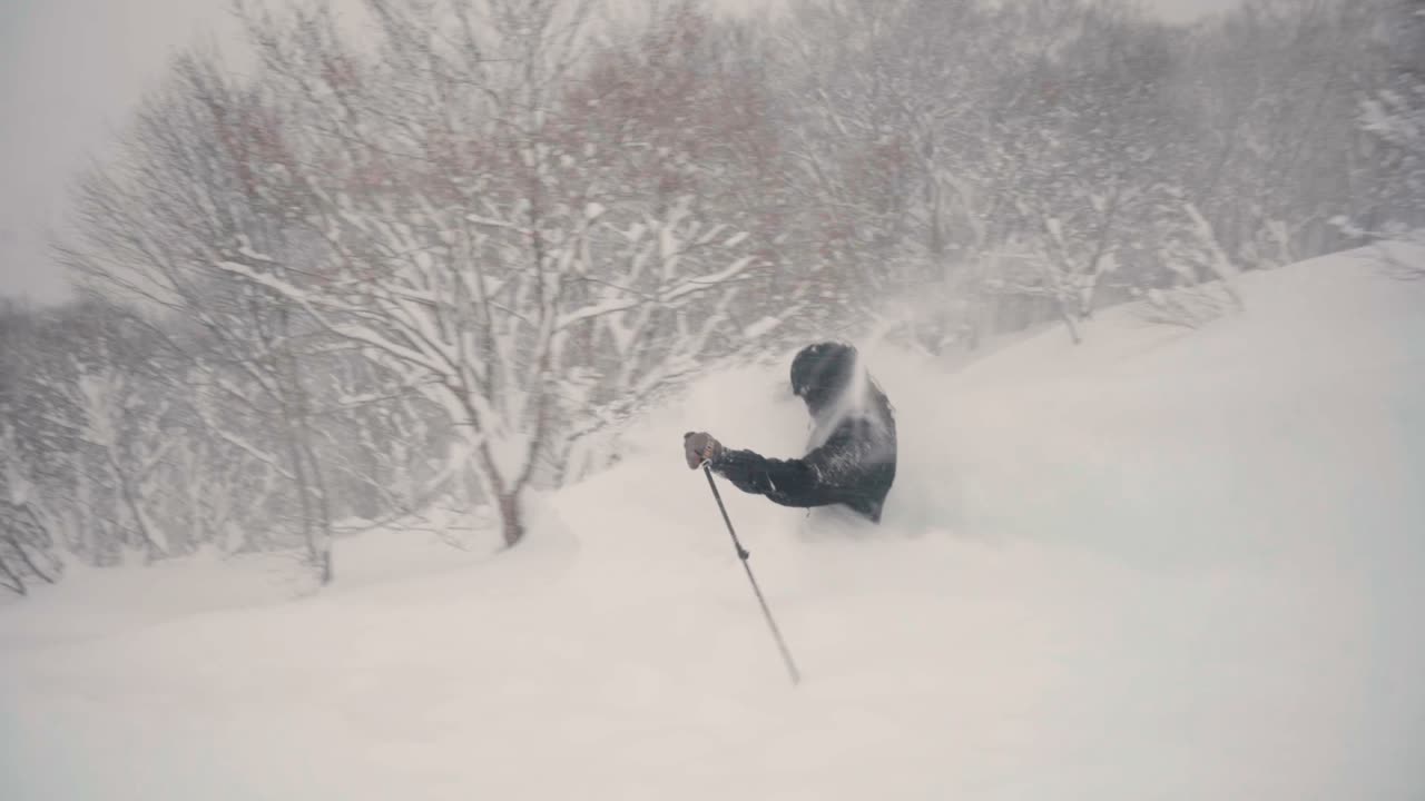 Skier sending snow through deep powder